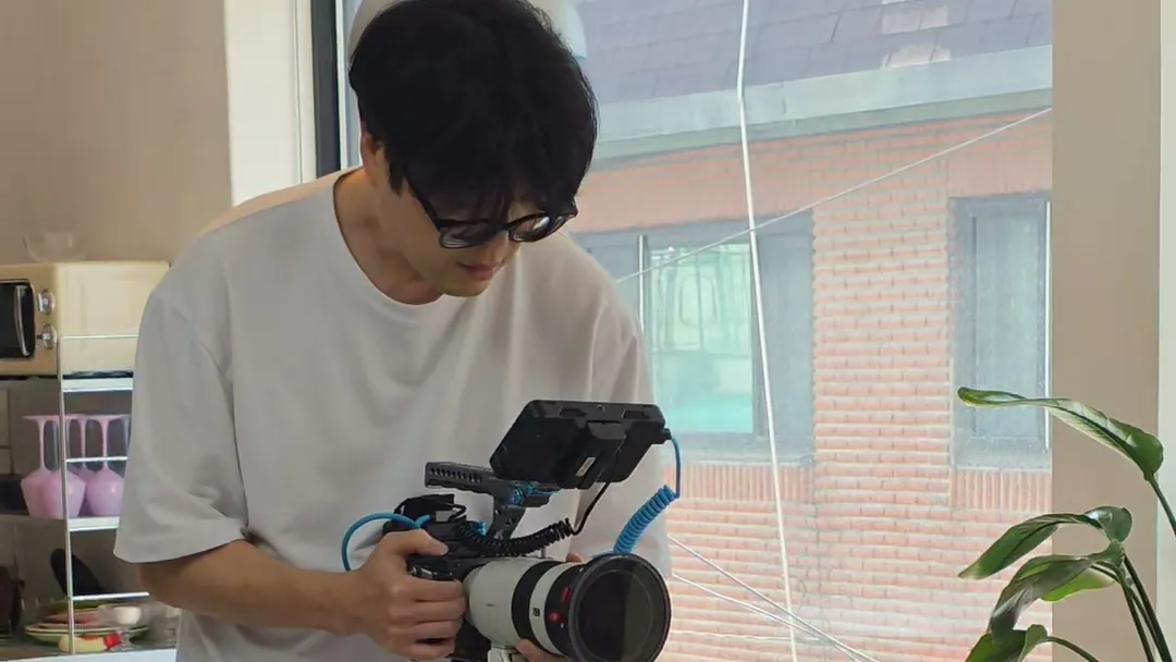 촬영 현장에서 모니터를 단 카메라 리그를 들고 화면을 내려다보는 모습