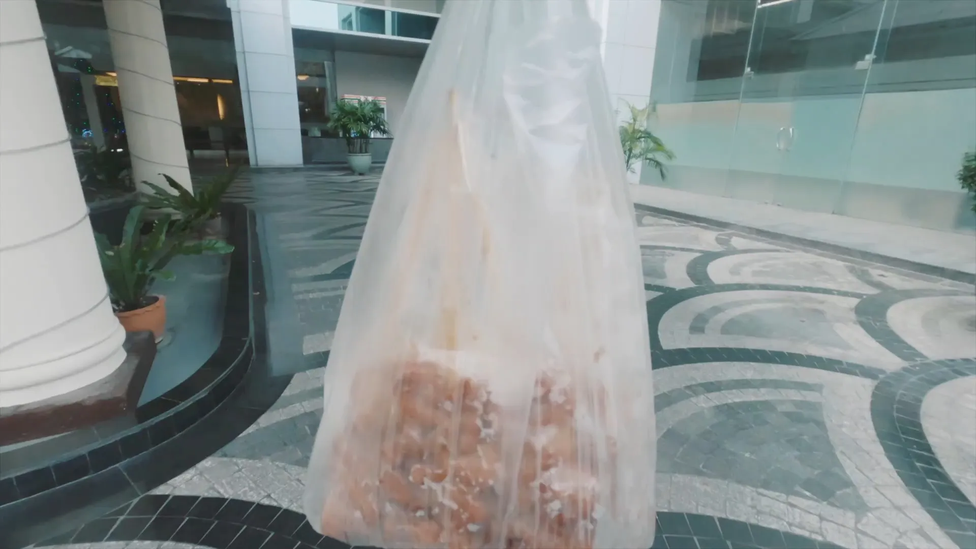 포장한 비닐봉지를 들고 아파트 앞 광장을 걸어간다