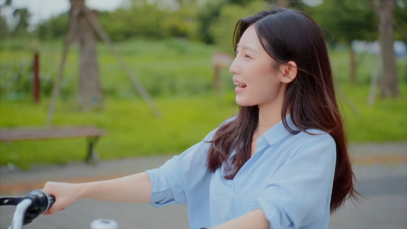 Walking a bicycle along, smiling