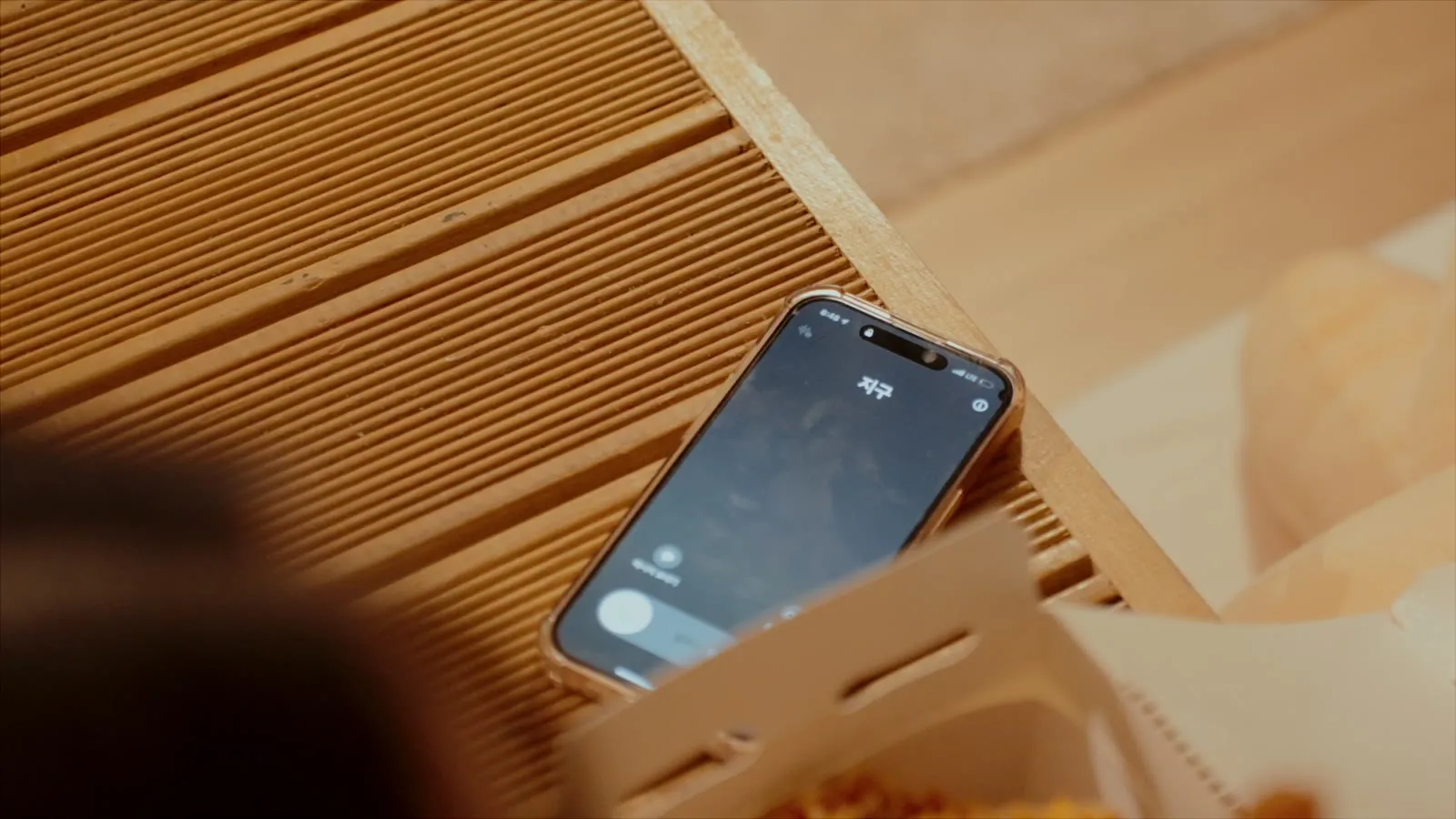 A phone lying on the floor. The caller's name is Earth