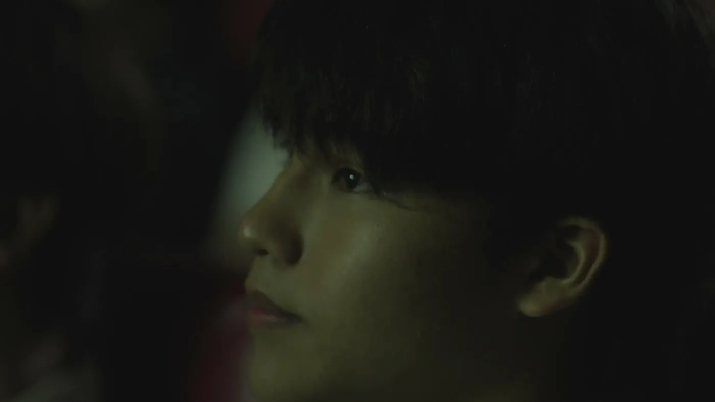 An audience member in profile, watching the screen