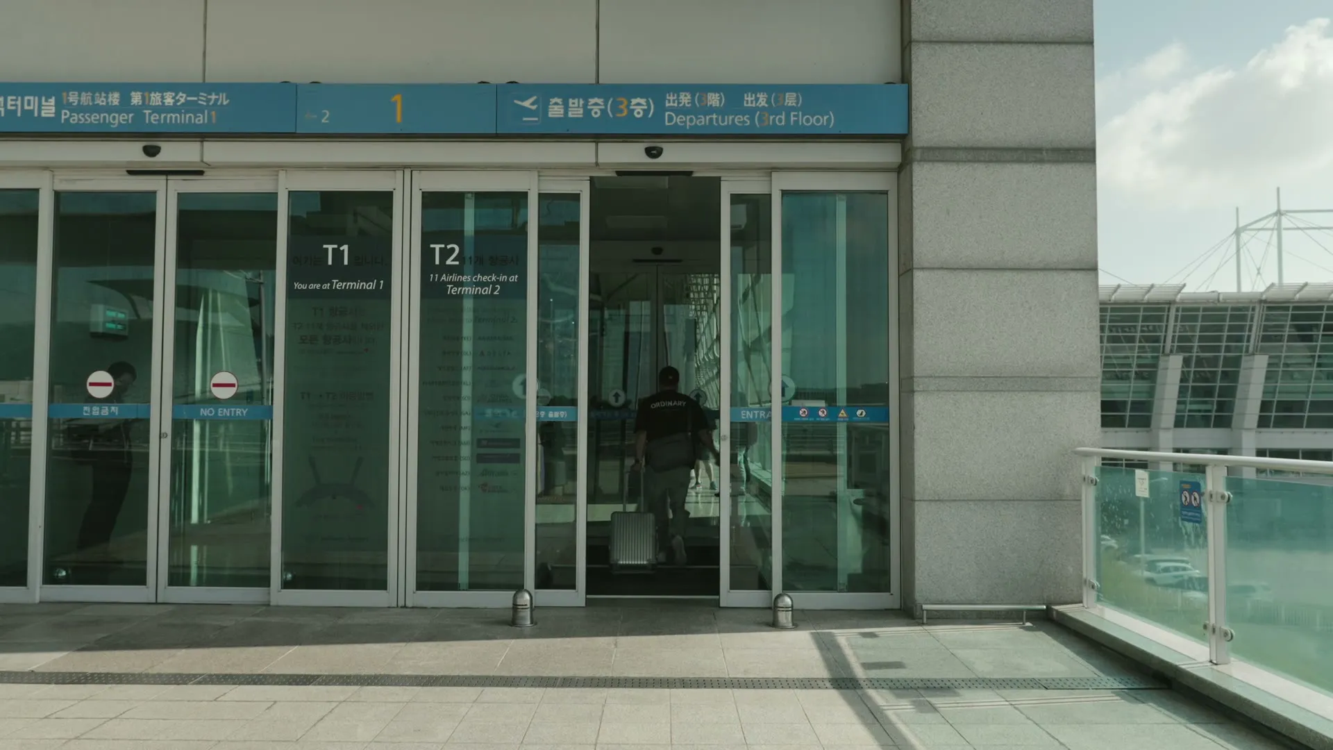 공항 출국장 자동문 안으로 캐리어를 끌고 들어가는 뒷모습
