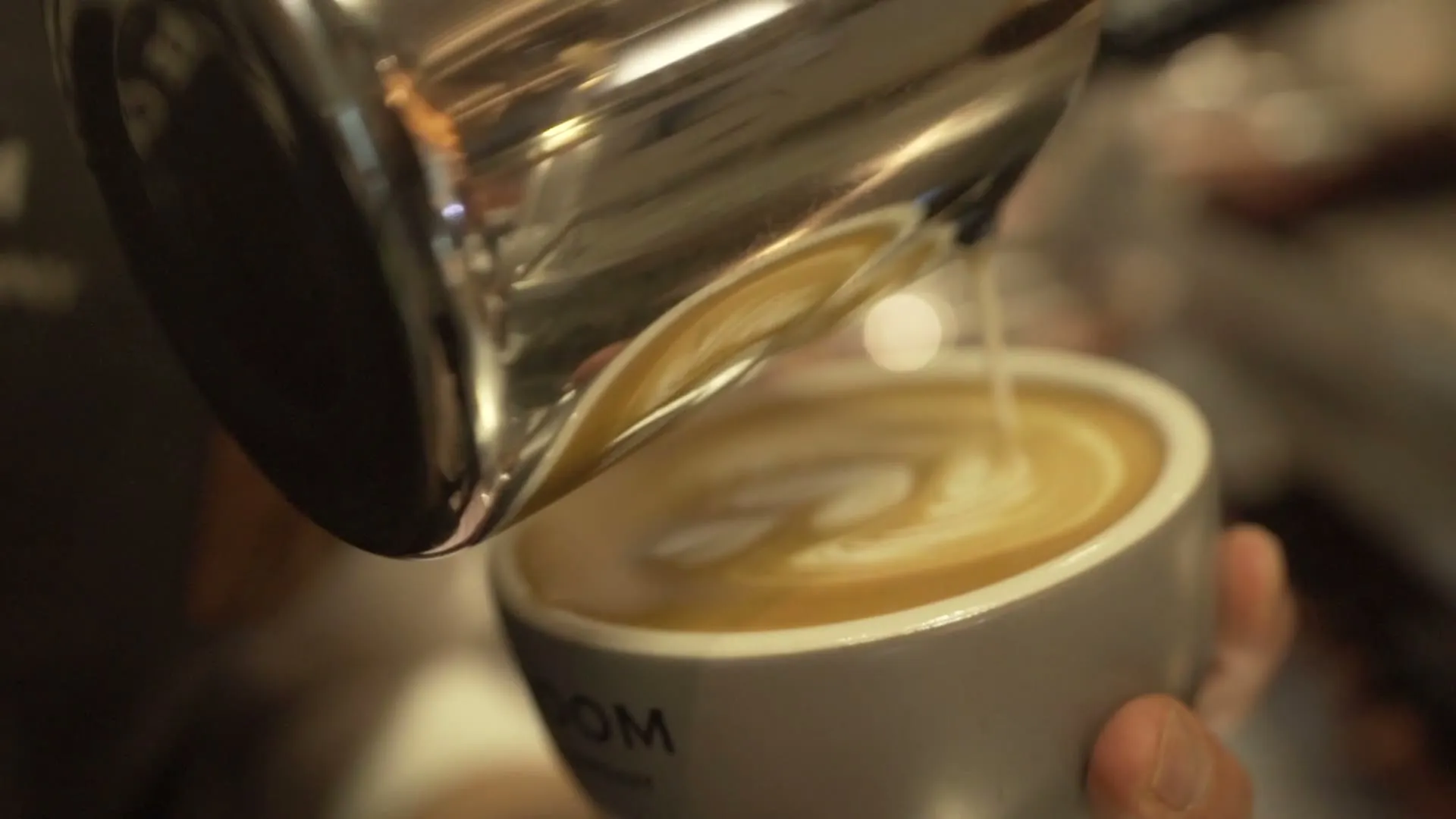 Hands pouring a latte